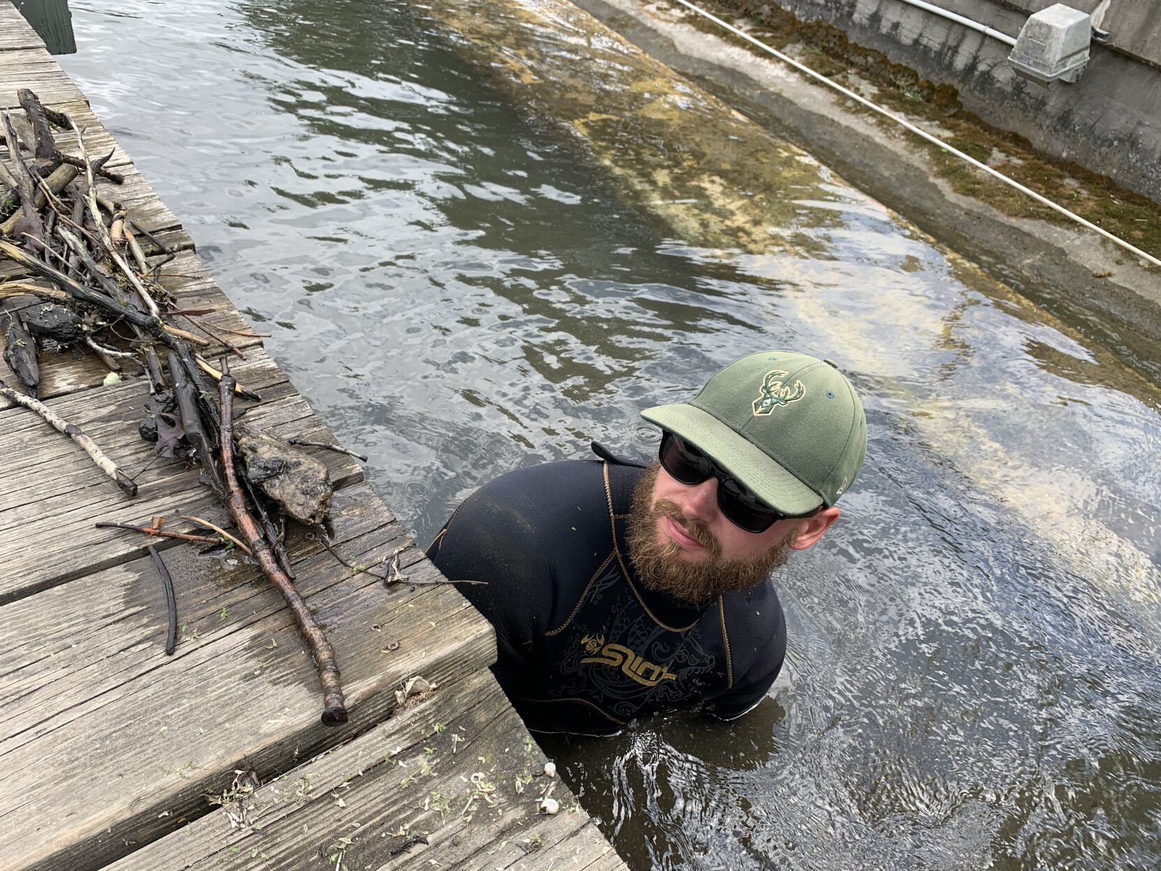 Brandon Riese, co-owner of Riese Aquatics LLC, removes form debris